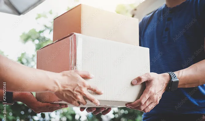 段ボール箱を丁寧に手渡しで配達・納品する様子